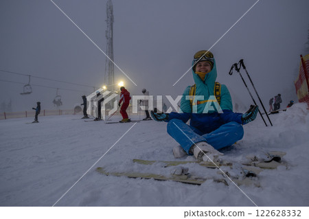 Skier Resting on Snowy Slope at Ski Resort Skier Resting on Snowy Slope at Ski Resort 122628332