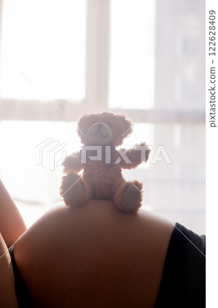 Pregnant Woman with toy Bear on Belly Pregnant Woman with toy Bear on Belly 122628409
