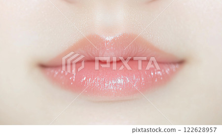 特寫鏡頭:年輕亞洲女性的嘴唇。她的嘴唇很可愛,塗著自然、水潤的粉紅色唇膏。 特寫鏡頭:年輕亞洲女性的嘴唇。她的嘴唇很可愛,塗著自然、水潤的粉紅色唇膏。 122628957