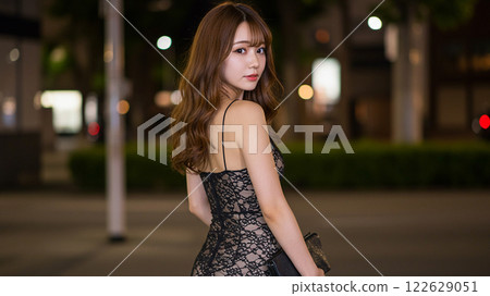 A woman in a black lace dress looking back exudes a sophisticated charm A woman in a black lace dress looking back exudes a sophisticated charm 122629051