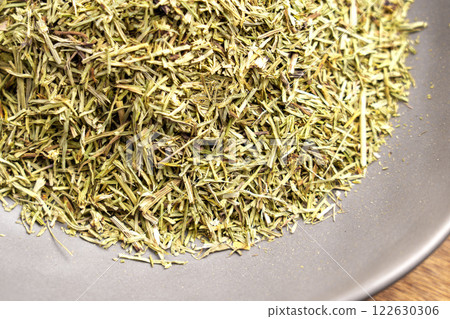 Medicinal healing horsetail tea leaves in ceramic bowl. Dried plant ingredient. Top view. Wellness concept 122630306