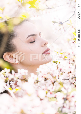 Beautiful woman portrait in sakura blossom background Beautiful woman portrait in sakura blossom background 122630452