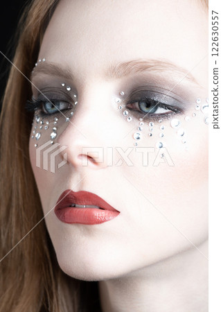 Beautiful woman portrait with glued jewelry on her face Beautiful woman portrait with glued jewelry on her face 122630557