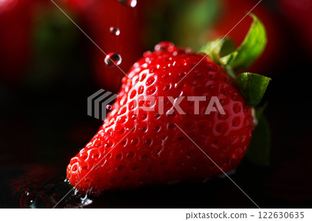 Water drops falling on strawberries Water drops falling on strawberries 122630635