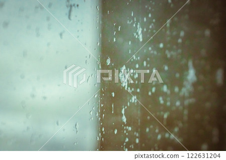 Rainy window view, Drops on glass on rainy cloudy day evoke melancholy and sadness. View of city from the window. Selective focus. High quality photo Rainy window view, Drops on glass on rainy cloudy day evoke melancholy and sadness. View of city from the window. Selective focus. High quality photo 122631204