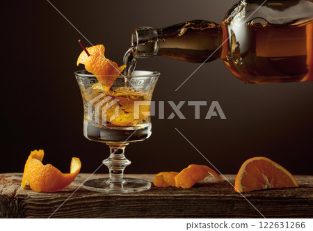 Old Fashioned cocktail with orange peel on a old wooden table. 122631266