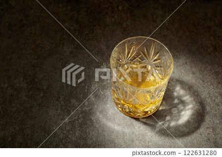 Crystal glass of whiskey on a old stone table. 122631280