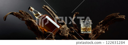 Bottle and glass of whiskey on a old snags. Bottle and glass of whiskey on a old snags. 122631284