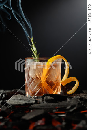 Old-fashioned cocktail  with a burning twig of rosemary. 122631300