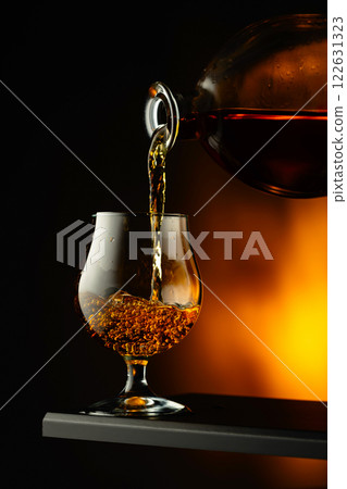 Cognac or brandy being poured into a glass. Cognac or brandy being poured into a glass. 122631323