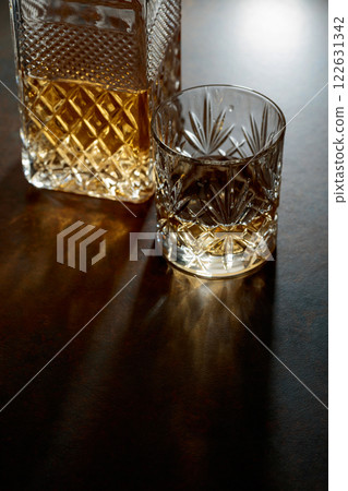 Decanter and cut glass tumbler with whiskey. 122631342