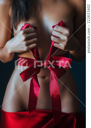 Elegant conceptual photography featuring a red ribbon wrapped around a woman's body. A woman's body with a red ribbon symbolizing elegance, celebration, and sensuality. Saint Valentine's Day concept Elegant conceptual photography featuring a red ribbon wrapped around a woman's body. A woman's body with a red ribbon symbolizing elegance, celebration, and sensuality. Saint Valentine's Day concept 122631602