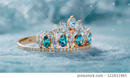 A gold ring designed like a crown with blue and white gems, copy space 122631965