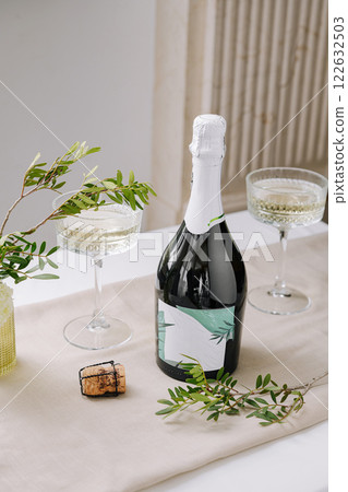 Celebratory moment featuring sparkling wine and elegant glassware with fresh greenery 122632503