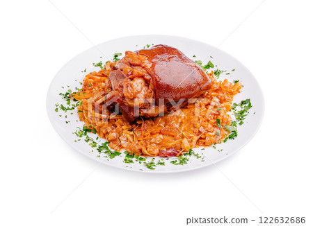 Savory pork knuckle served with flavorful sauerkraut and garnished with fresh herbs 122632686