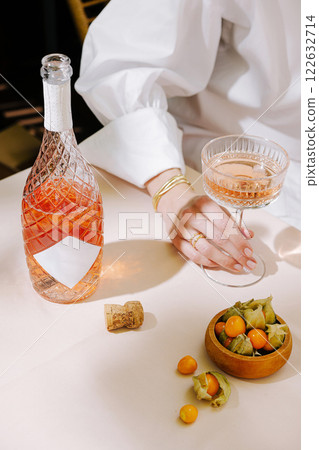 Elegant drink presentation with rose-colored beverage and fresh accompaniments on a dining table Elegant drink presentation with rose-colored beverage and fresh accompaniments on a dining table 122632714