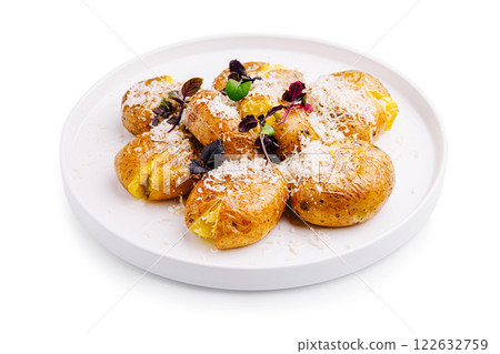 Delicious roasted potatoes topped with cheese and herbs served on a white plate Delicious roasted potatoes topped with cheese and herbs served on a white plate 122632759