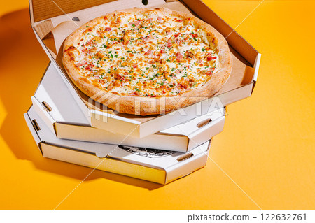 Delicious pizza in a takeout box stacked on colorful background ready to be enjoyed with friends or family Delicious pizza in a takeout box stacked on colorful background ready to be enjoyed with friends or family 122632761