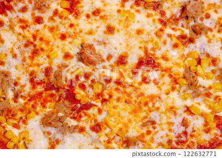 Delicious pizza topped with corn and meat, served fresh from the oven in a cozy kitchen 122632771