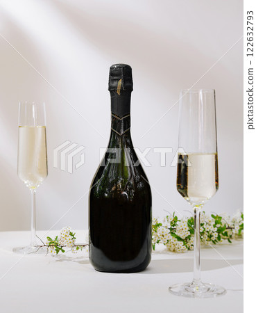 Celebration with sparkling wine and elegant flutes surrounded by fresh flowers on a white tablecloth 122632793