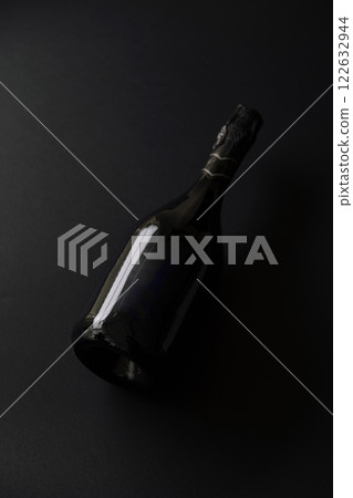 Black bottle of sparkling wine set against a dark background highlighting its elegant shape and design Black bottle of sparkling wine set against a dark background highlighting its elegant shape and design 122632944