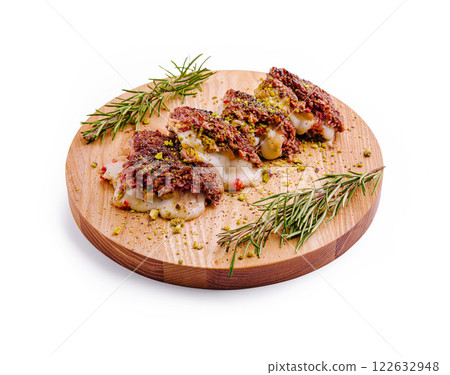 Delightful presentation of gourmet stuffed pastries on a wooden board with herbs and spices 122632948