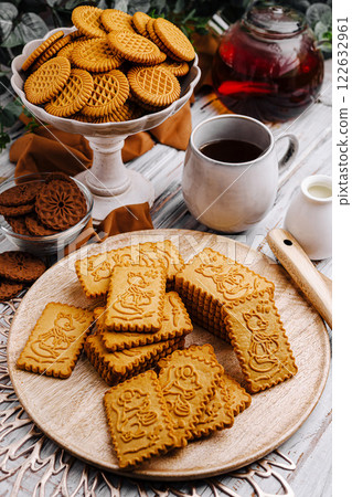 Enjoying an afternoon tea with assorted cookies and herbal tea in a cozy setting Enjoying an afternoon tea with assorted cookies and herbal tea in a cozy setting 122632961