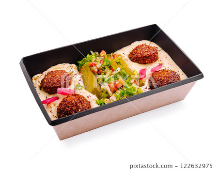 Delicious falafel platter with fresh vegetables and creamy sauce served in a reusable container 122632975