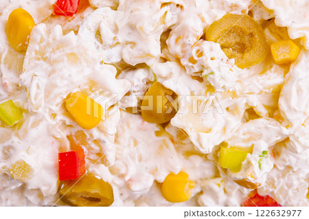 Delicious creamy pasta salad with colorful vegetables and olives served in a bowl at a summer picnic Delicious creamy pasta salad with colorful vegetables and olives served in a bowl at a summer picnic 122632977