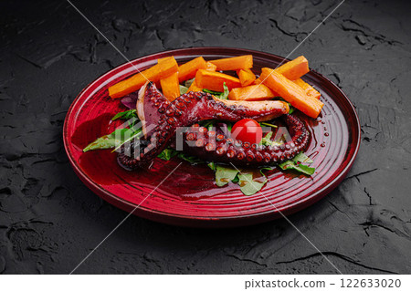 Delicious grilled octopus served on a vibrant plate with sweet potato fries and fresh greens at a restaurant Delicious grilled octopus served on a vibrant plate with sweet potato fries and fresh greens at a restaurant 122633020