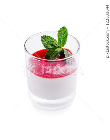 Creamy panna cotta dessert topped with vibrant raspberry sauce and fresh mint leaves in a glass Creamy panna cotta dessert topped with vibrant raspberry sauce and fresh mint leaves in a glass 122633044