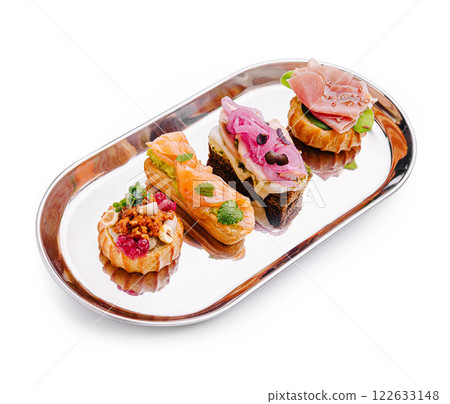 Delicious assortment of gourmet appetizers arranged on a metal platter in a stylish setting Delicious assortment of gourmet appetizers arranged on a metal platter in a stylish setting 122633148