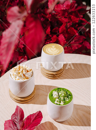 Warm drinks served in stylish mugs with autumn foliage accents in a cozy cafe setting Warm drinks served in stylish mugs with autumn foliage accents in a cozy cafe setting 122633153