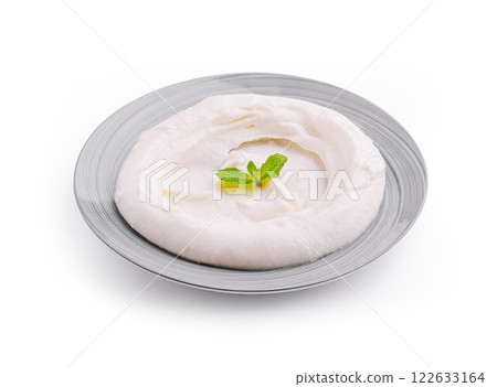 Creamy mashed potatoes served with a fresh mint leaf on a decorative gray plate 122633164
