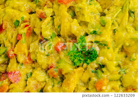 Guacamole prepared with fresh ingredients at a vibrant outdoor gathering in sunny weather 122633209