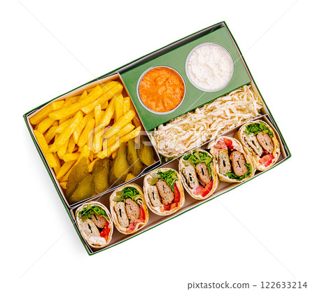 Delicious wrapped sandwiches with fries and sides in a takeout box from a local eatery Delicious wrapped sandwiches with fries and sides in a takeout box from a local eatery 122633214