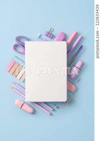 Composition of various school and office stationery in pastel pink and purple colors on a blue background. Place for your text. 122633439
