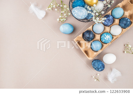 Easter eggs on rustic table with blossoms spring flowers. Natural dyed colorful eggs in paper tray. Happy Easter. top view. copy space Easter eggs on rustic table with blossoms spring flowers. Natural dyed colorful eggs in paper tray. Happy Easter. top view. copy space 122633908