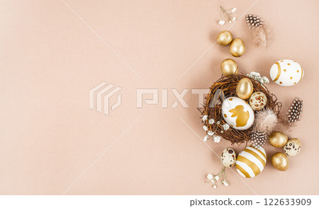 Easter eggs in a nest on beige background. Stylish golden eggs. Happy Easter card. top view. copy space 122633909