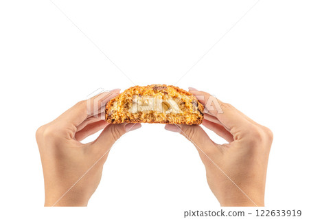 Hands of caucasian young woman holding delicious cookie over isolated white background Hands of caucasian young woman holding delicious cookie over isolated white background 122633919