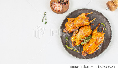 Delicious fried quail with herbs on plate on a white background top view. copy space 122633924