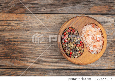 A variety of Natural Spices pepper peas and pink Salt in a Rustic Bowl on a Wooden Table Top view. Free copy space A variety of Natural Spices pepper peas and pink Salt in a Rustic Bowl on a Wooden Table Top view. Free copy space 122633927