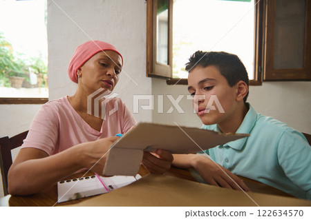 Mother and son collaborating on a project at a home table 122634570