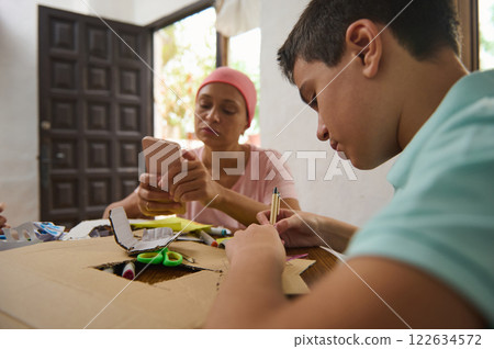 Mother and son engaging in creative craft activities at home 122634572