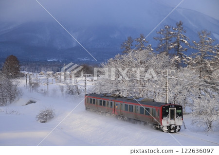 信濃鐵道 SR1 系列車疾馳而過，揚起雪花和煙霧，背景是黑姬山的壯麗景色_照片拍攝於 2025 年 1 月 1 日 122636097
