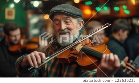 Elderly man playing the violin in Irish pub, surrounded by others celebrating with traditional music. Warmth 122636235