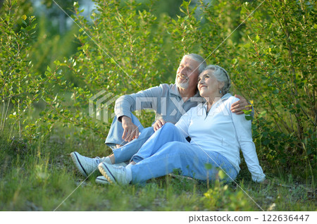 Portrait of senior couple sitting on the grass in the park Portrait of senior couple sitting on the grass in the park 122636447