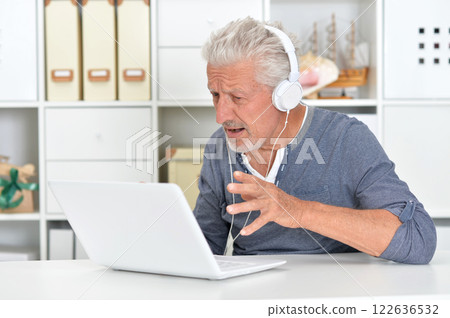 Portrait of senior man with laptop at home 122636532
