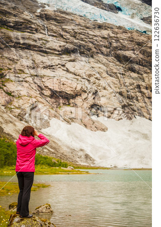 Tourist admiring Boyabreen Glacier in Norway 122636730