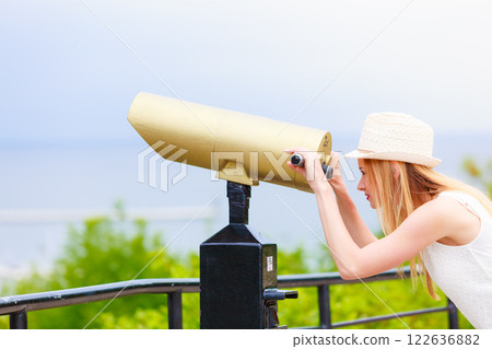 Woman tourist with sun hat looking through telescope Woman tourist with sun hat looking through telescope 122636882
